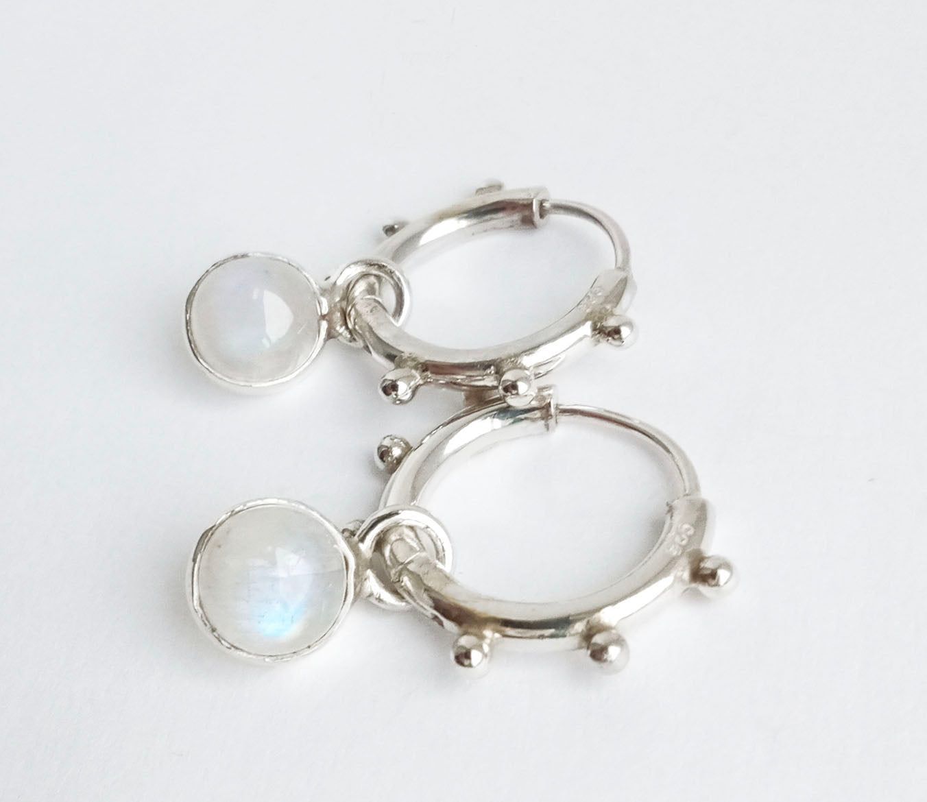 Mystic moonstone briolettes sparkle inside shiny sterling silver hoop earrings on custom ear wires. Mystic moonstone takes shops on colors near by